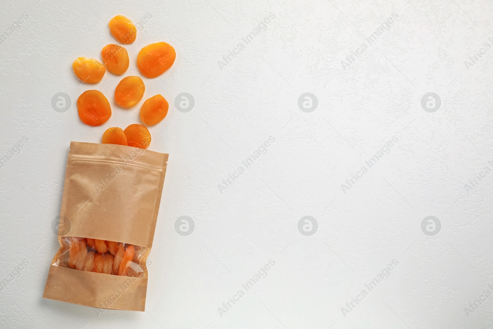 Zipper stand-up pouch with dried apricots on white table, flat lay. Mockup for design Photo of Zipper stand-up pouch with dried apricots on white table, flat lay. Mockup for design