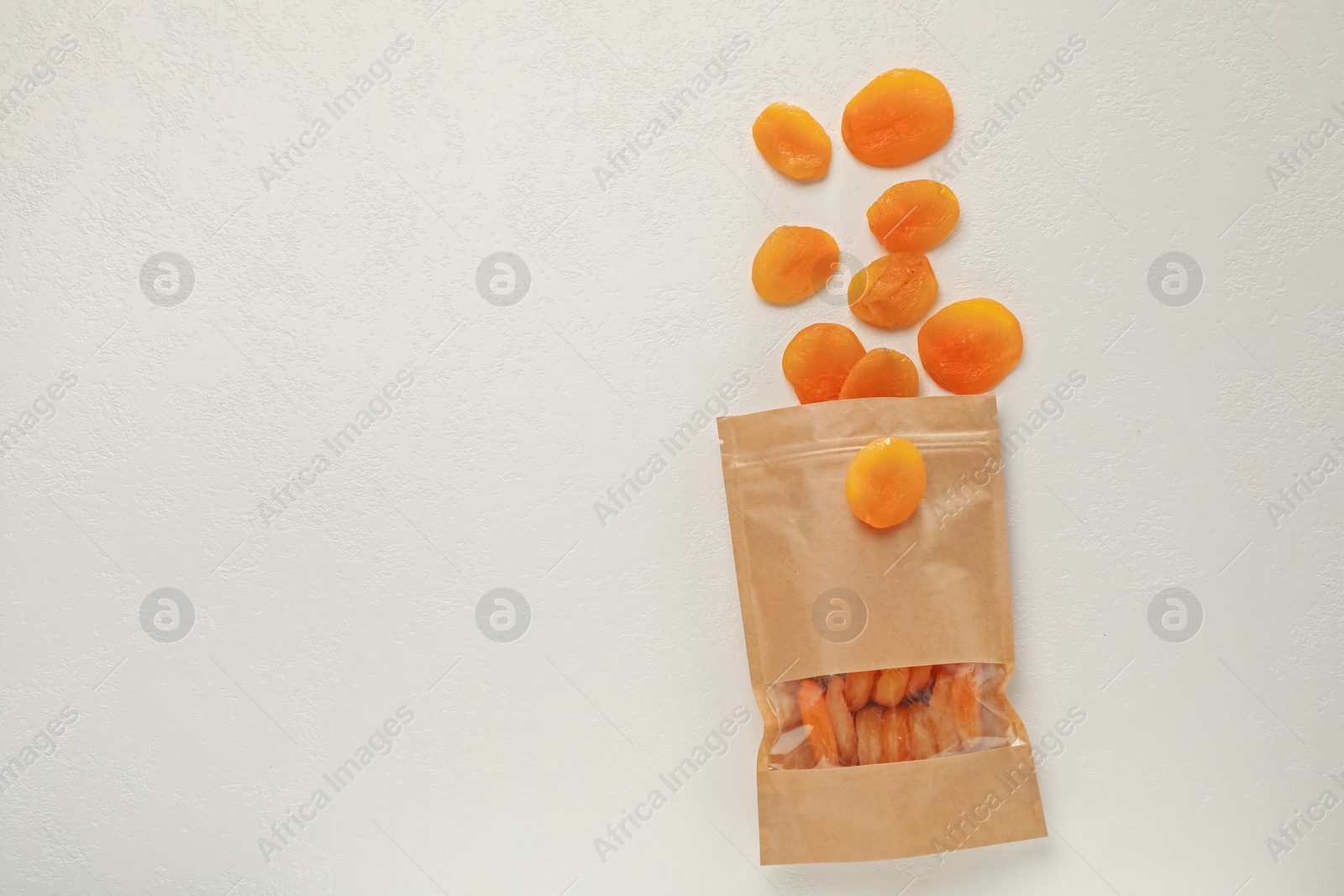 Zipper stand-up pouch with dried apricots on white table, flat lay. Mockup for design Photo of Zipper stand-up pouch with dried apricots on white table, flat lay. Mockup for design