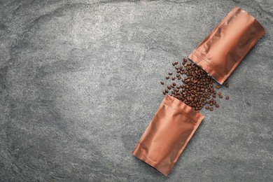 Photo of Zipper stand-up pouches and coffee beans on grey table, flat lay. Mockup for design