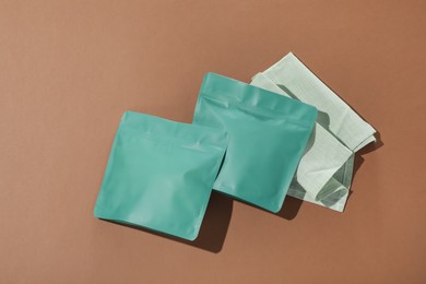 Photo of Zipper stand-up pouches on brown background, flat lay. Mockup for design