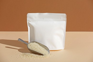 Photo of Zipper stand-up pouch and white rice on color background, mockup for design