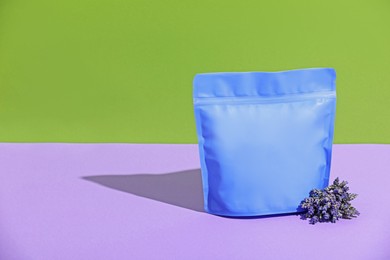 Photo of Zipper stand-up pouch and lavender flowers on color background, mockup for design
