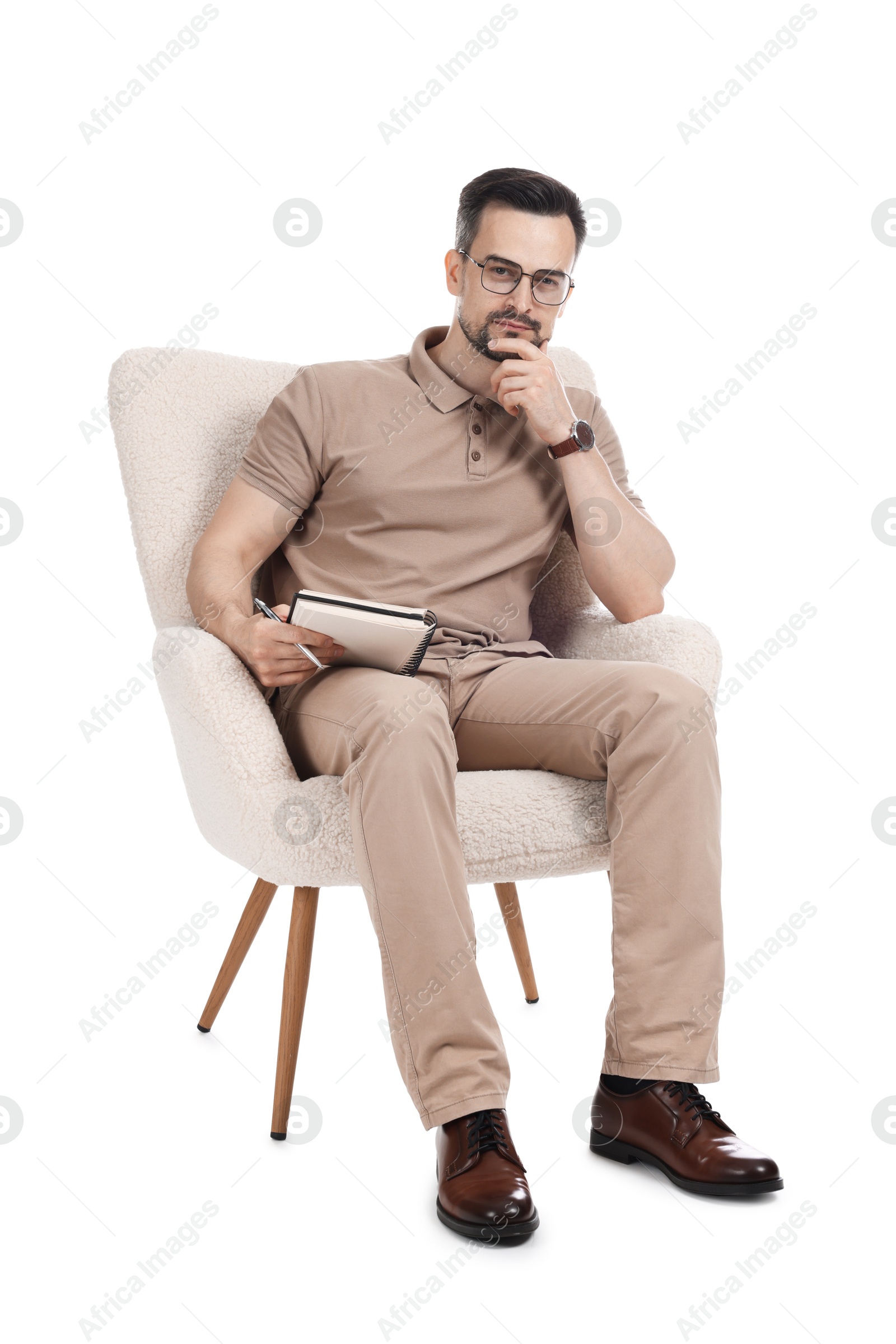 Professional psychologist with notebook in armchair on white background Photo of Professional psychologist with notebook in armchair on white background