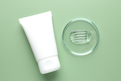 Photo of Cosmetic product in Petri dish and tube on green background, flat lay