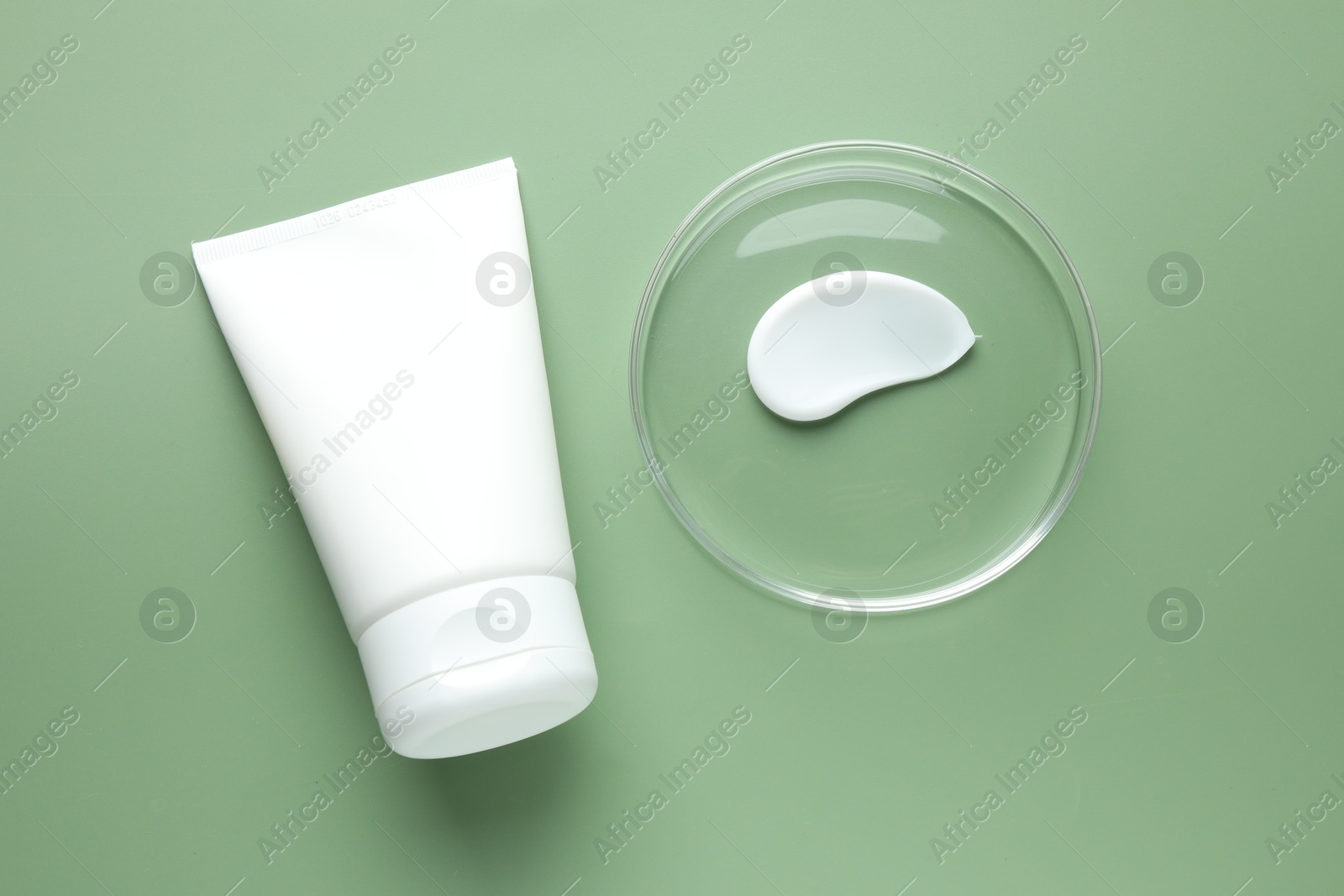 Cosmetic product in Petri dish and tube on green background, flat lay Photo of Cosmetic product in Petri dish and tube on green background, flat lay