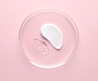 Photo of Different cosmetic products in Petri dish on pink background, top view