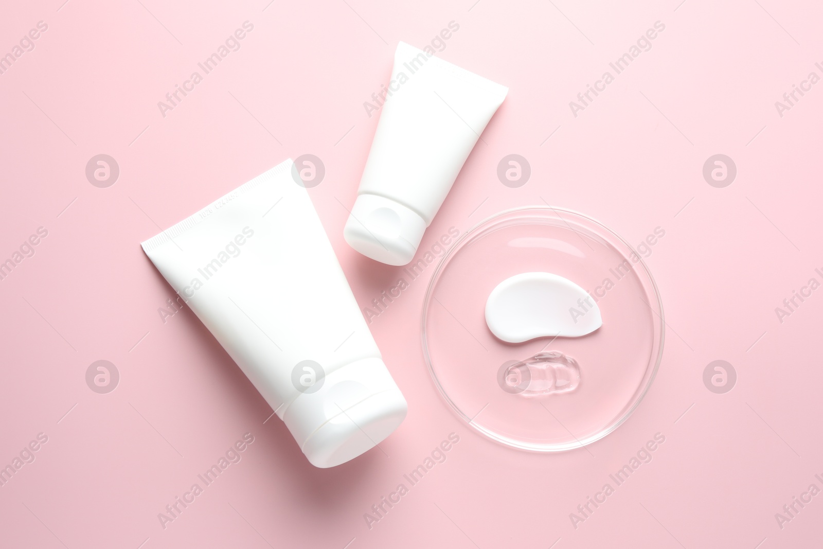 Different cosmetic products in Petri dish and tubes on pink background, flat lay Photo of Different cosmetic products in Petri dish and tubes on pink background, flat lay
