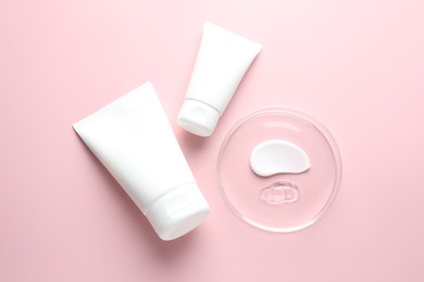 Photo of Different cosmetic products in Petri dish and tubes on pink background, flat lay