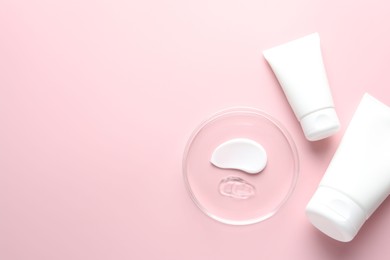 Photo of Different cosmetic products in Petri dish and tubes on pink background, flat lay. Space for text