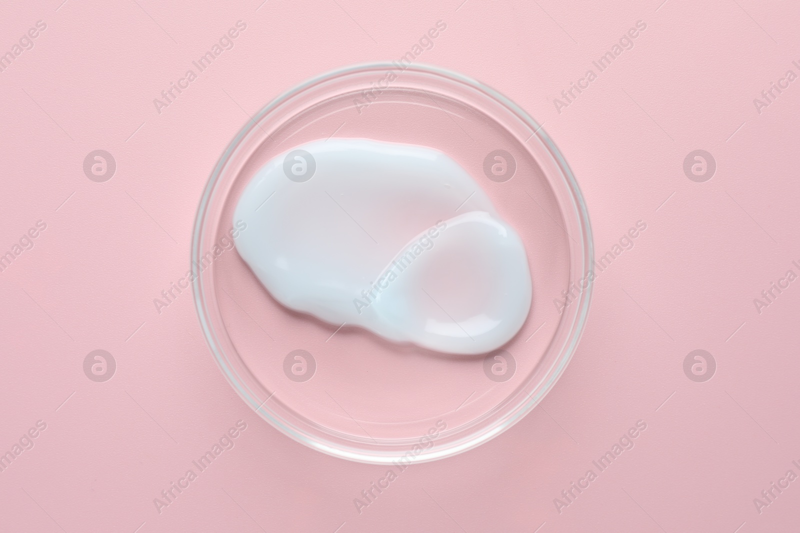Cosmetic product in Petri dish on pink background, top view Photo of Cosmetic product in Petri dish on pink background, top view