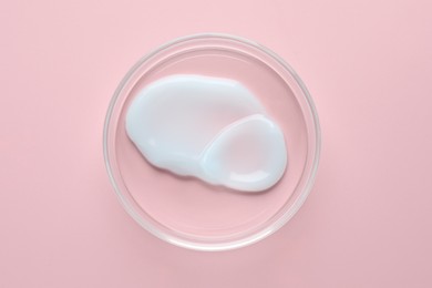 Photo of Cosmetic product in Petri dish on pink background, top view
