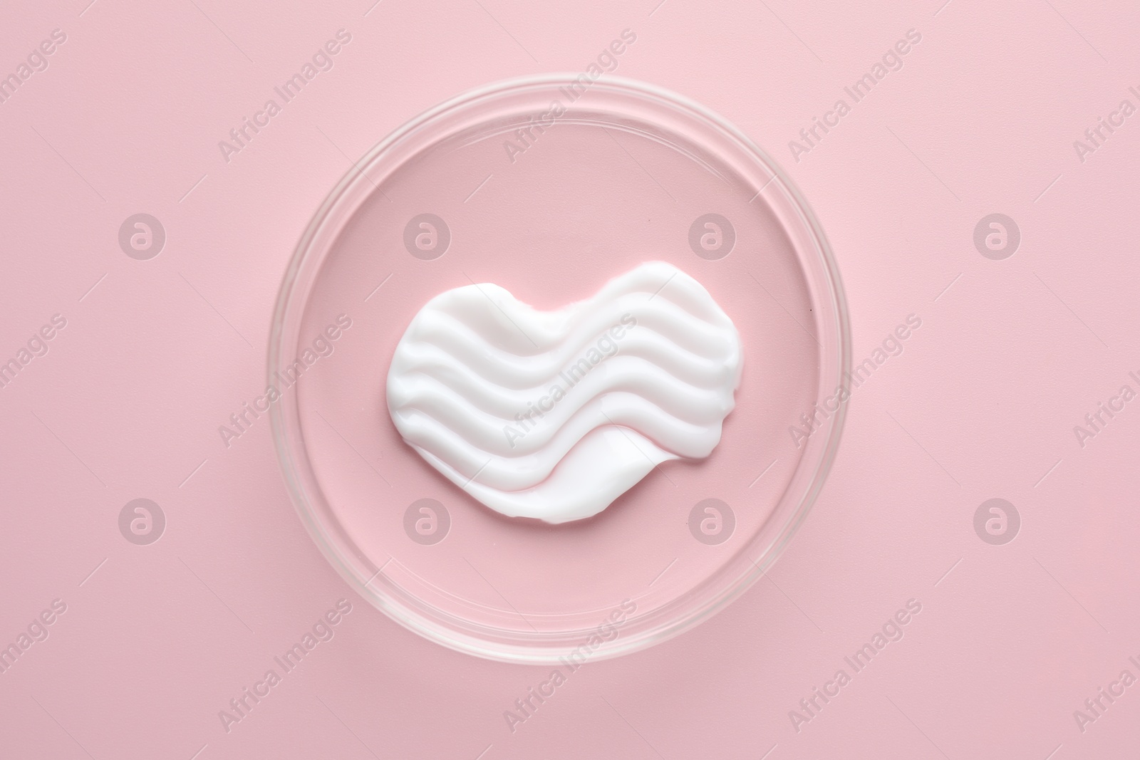 Cosmetic product in Petri dish on pink background, top view Photo of Cosmetic product in Petri dish on pink background, top view