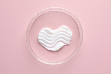 Photo of Cosmetic product in Petri dish on pink background, top view
