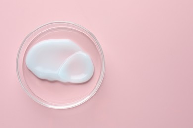 Photo of Cosmetic product in Petri dish on pink background, top view. Space for text