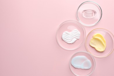 Photo of Different cosmetic products in Petri dishes on pink background, flat lay. Space for text