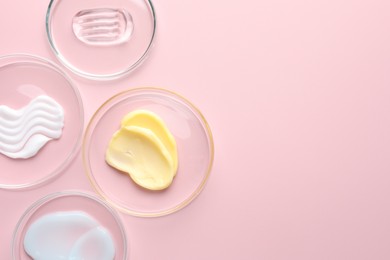 Photo of Different cosmetic products in Petri dishes on pink background, flat lay. Space for text