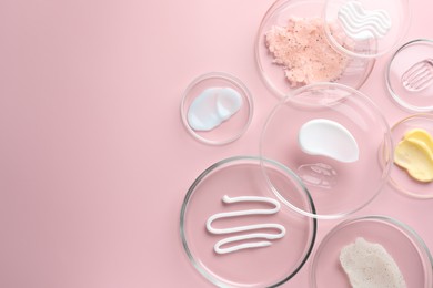 Photo of Different cosmetic products in Petri dishes on pink background, flat lay. Space for text
