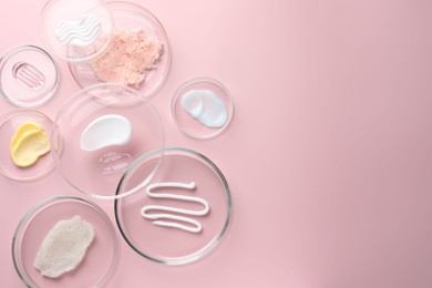 Photo of Different cosmetic products in Petri dishes on pink background, flat lay. Space for text