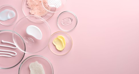 Photo of Different cosmetic products in Petri dishes on pink background, flat lay. Space for text
