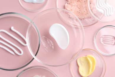 Photo of Different cosmetic products in Petri dishes on pink background, flat lay