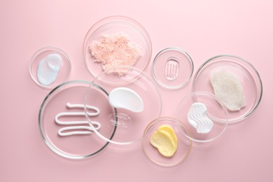 Photo of Different cosmetic products in Petri dishes on pink background, flat lay