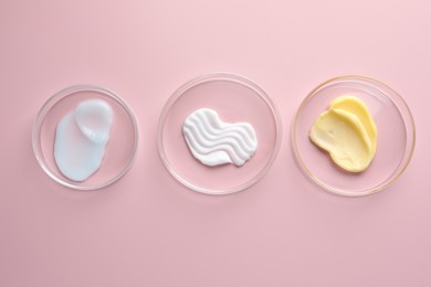 Photo of Different cosmetic products in Petri dishes on pink background, flat lay