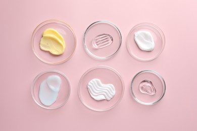 Photo of Different cosmetic products in Petri dishes on pink background, flat lay