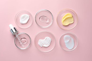 Photo of Different cosmetic products in Petri dishes and dropper on pink background, flat lay