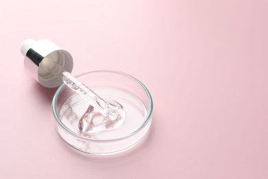 Photo of Cosmetic product in Petri dish and dropper on pink background, closeup. Space for text