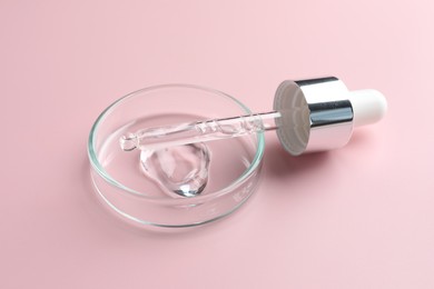 Photo of Cosmetic product in Petri dish and dropper on pink background, closeup