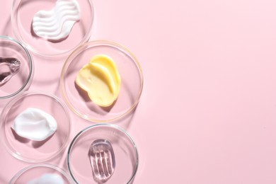 Photo of Different cosmetic products in Petri dishes on pink background, flat lay. Space for text
