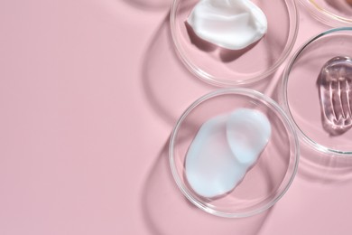 Photo of Different cosmetic products in Petri dishes on pink background, flat lay. Space for text