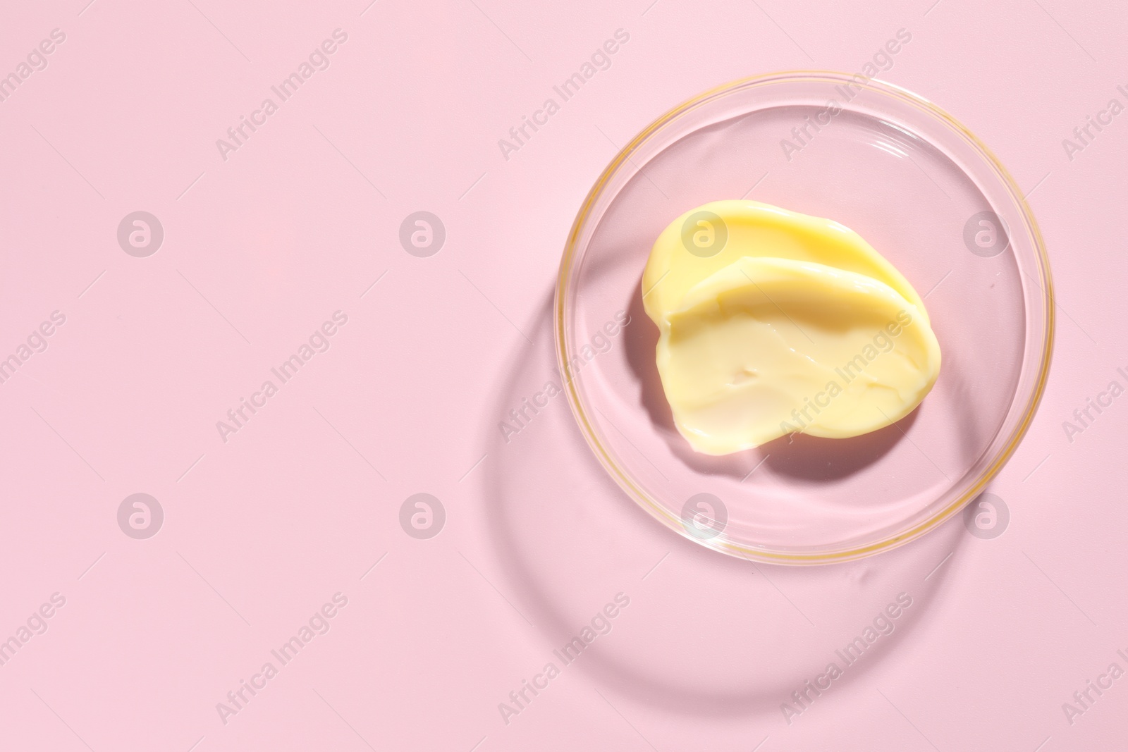 Cosmetic product in Petri dish on pink background, top view. Space for text Photo of Cosmetic product in Petri dish on pink background, top view. Space for text