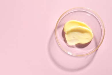 Photo of Cosmetic product in Petri dish on pink background, top view. Space for text