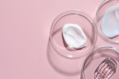 Photo of Different cosmetic products in Petri dishes on pink background, flat lay. Space for text
