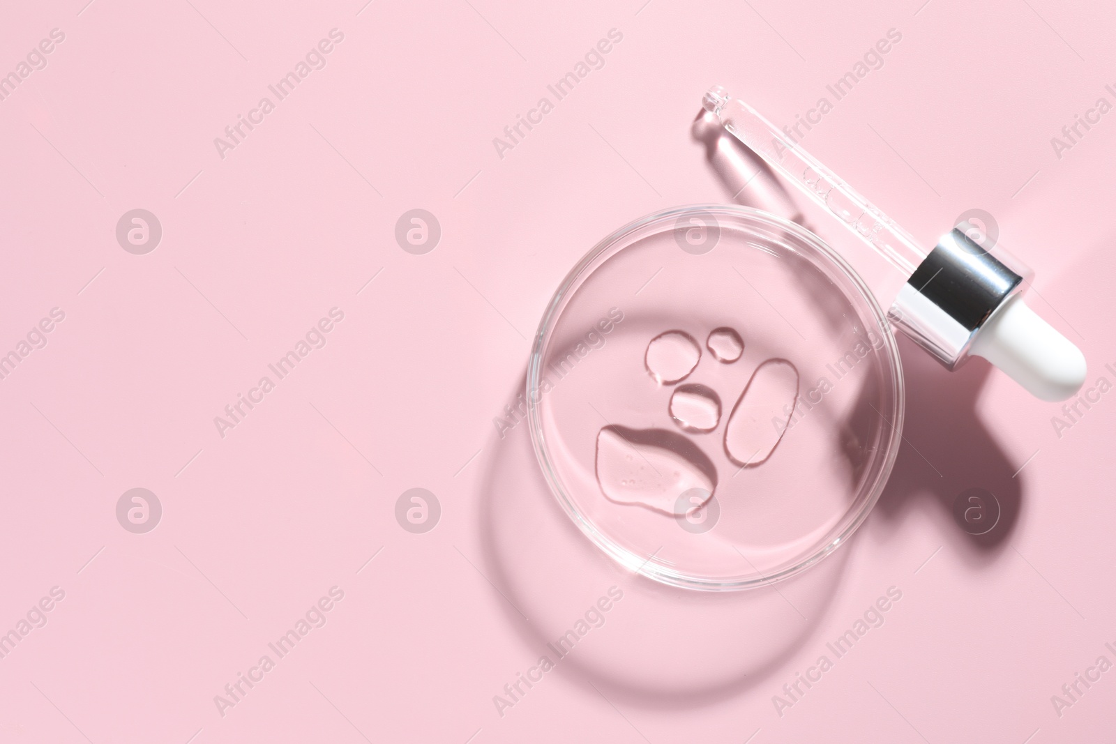 Cosmetic product in Petri dish and dropper on pink background, flat lay. Space for text Photo of Cosmetic product in Petri dish and dropper on pink background, flat lay. Space for text