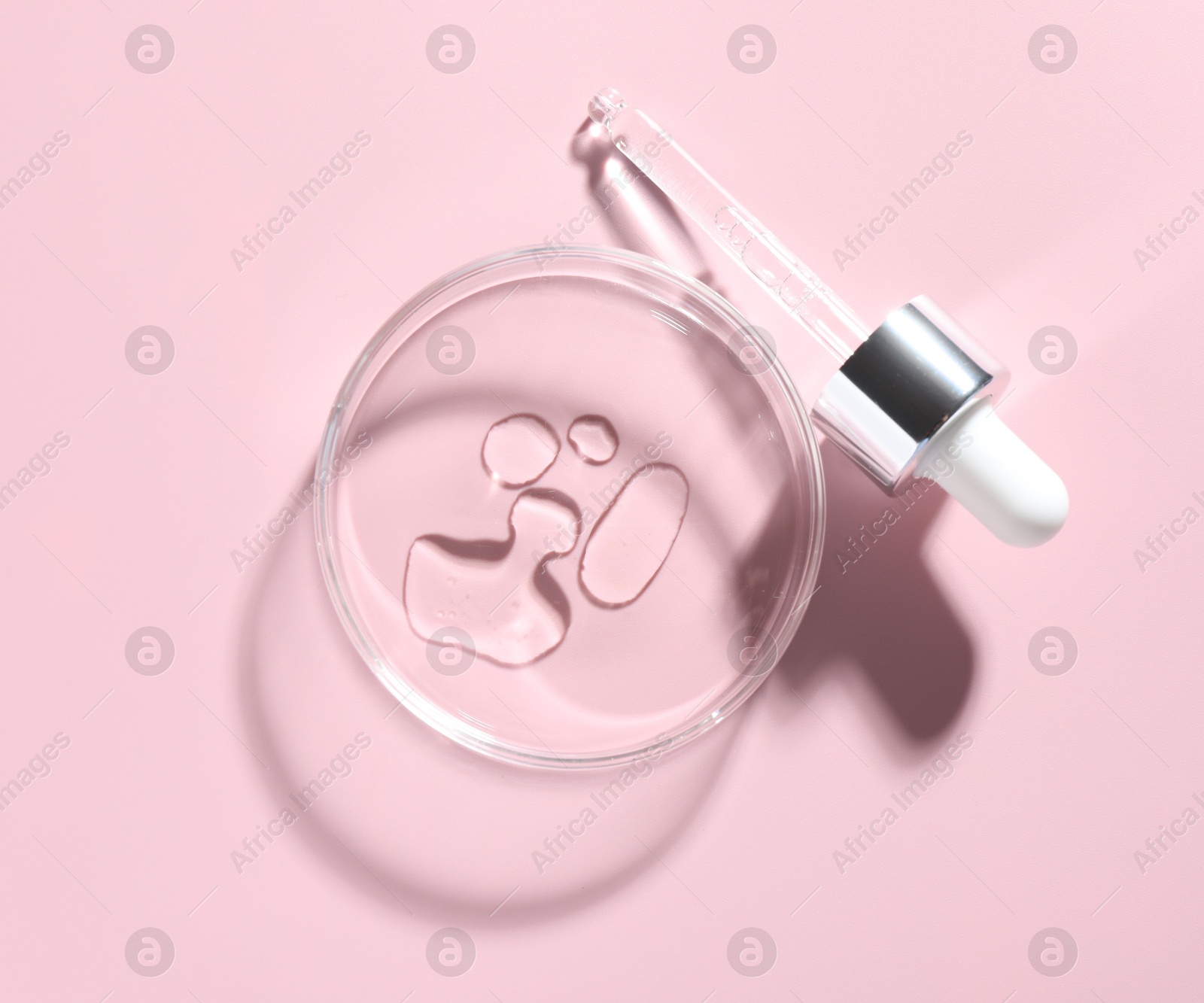 Cosmetic product in Petri dish and dropper on pink background, flat lay Photo of Cosmetic product in Petri dish and dropper on pink background, flat lay