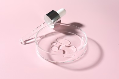 Photo of Cosmetic product in Petri dish and dropper on pink background, closeup
