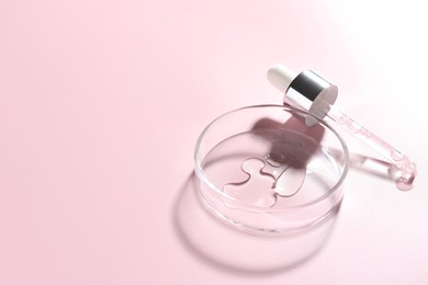 Photo of Cosmetic product in Petri dish and dropper on pink background, closeup. Space for text