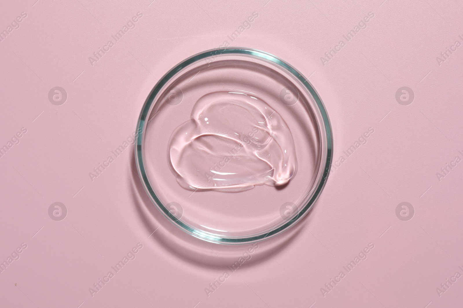 Cosmetic product in Petri dish on pink background, top view Photo of Cosmetic product in Petri dish on pink background, top view