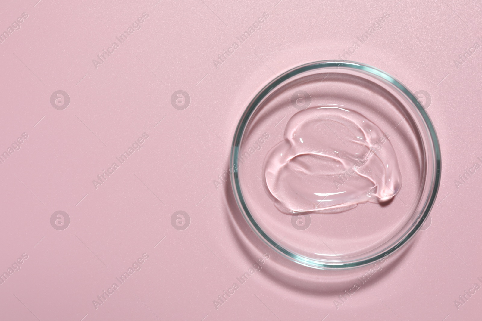 Cosmetic product in Petri dish on pink background, top view. Space for text Photo of Cosmetic product in Petri dish on pink background, top view. Space for text