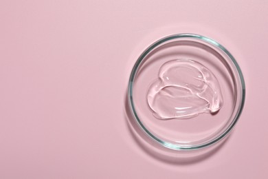 Photo of Cosmetic product in Petri dish on pink background, top view. Space for text