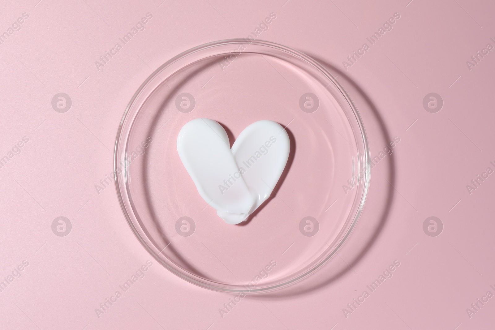 Cosmetic product in Petri dish on pink background, top view Photo of Cosmetic product in Petri dish on pink background, top view