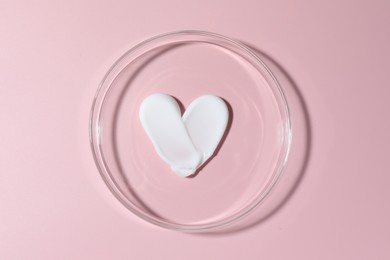 Photo of Cosmetic product in Petri dish on pink background, top view