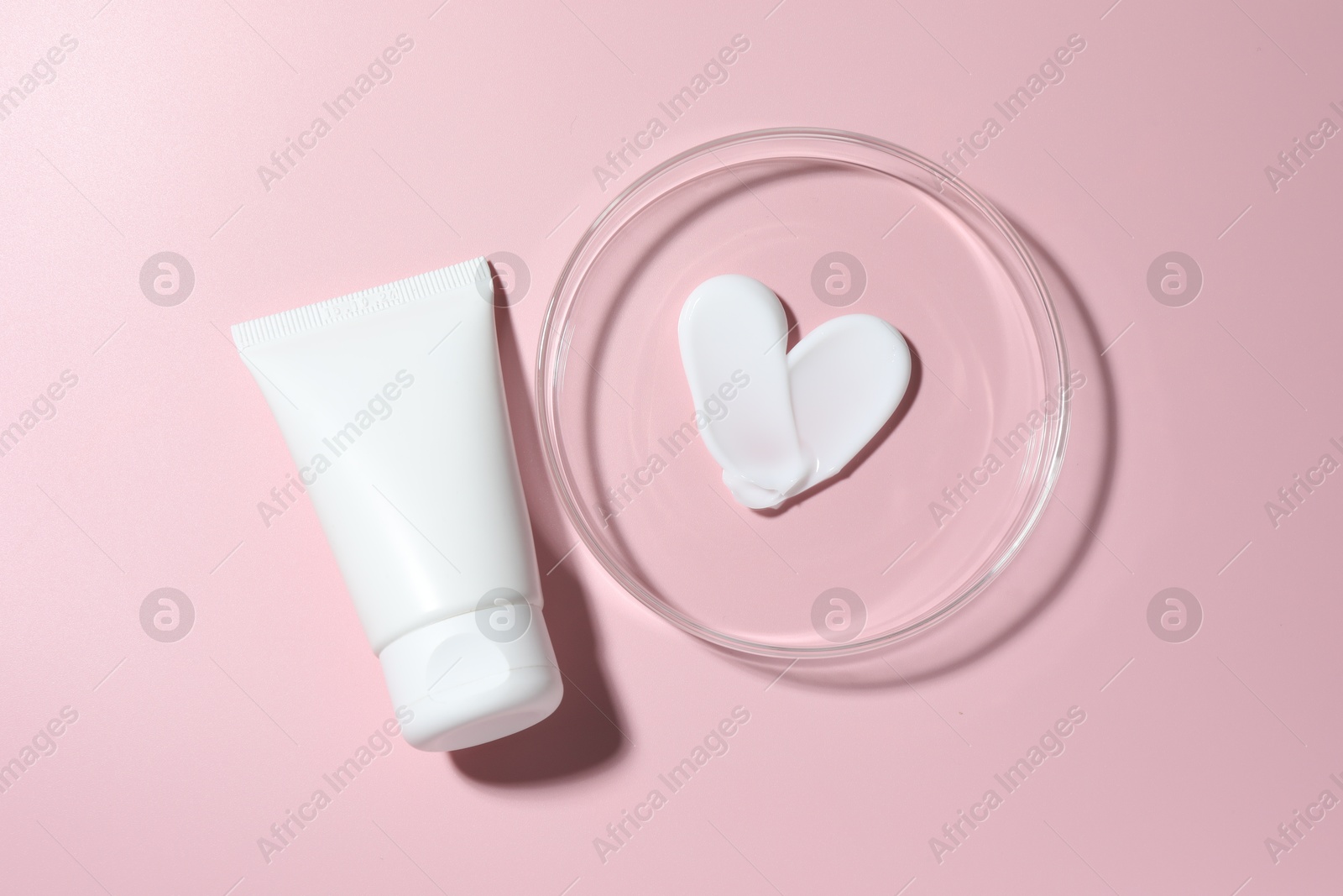 Cosmetic product in Petri dish and tube on pink background, flat lay Photo of Cosmetic product in Petri dish and tube on pink background, flat lay