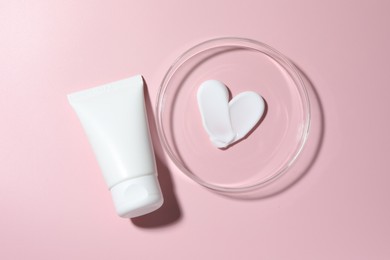 Photo of Cosmetic product in Petri dish and tube on pink background, flat lay
