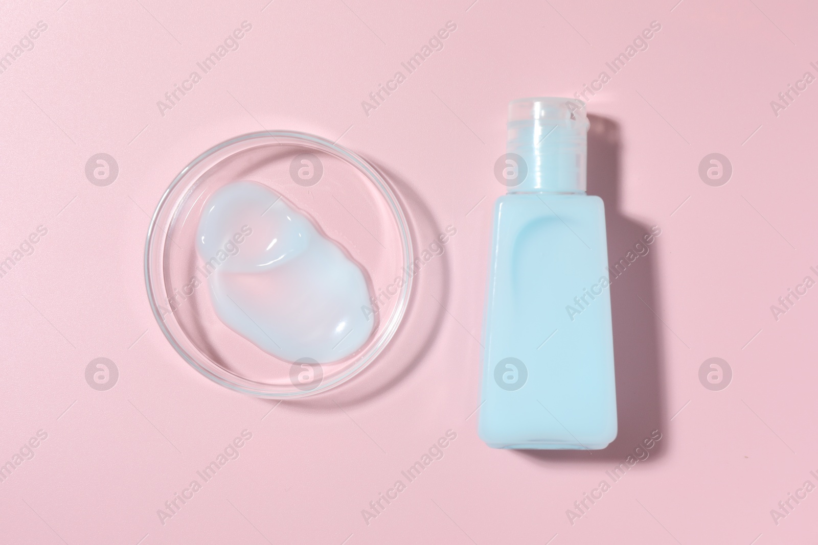 Cosmetic product in Petri dish and bottle on pink background, flat lay Photo of Cosmetic product in Petri dish and bottle on pink background, flat lay