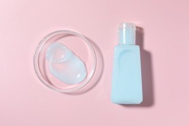 Photo of Cosmetic product in Petri dish and bottle on pink background, flat lay
