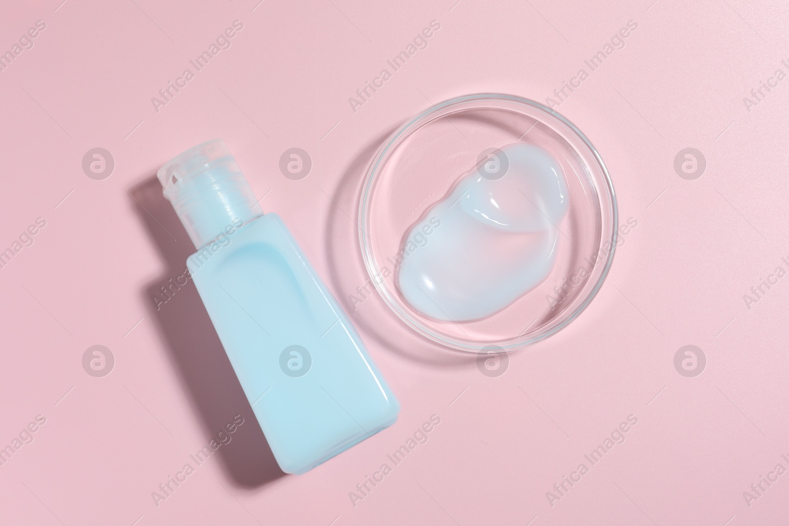 Cosmetic product in Petri dish and bottle on pink background, flat lay Photo of Cosmetic product in Petri dish and bottle on pink background, flat lay