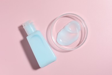 Photo of Cosmetic product in Petri dish and bottle on pink background, flat lay